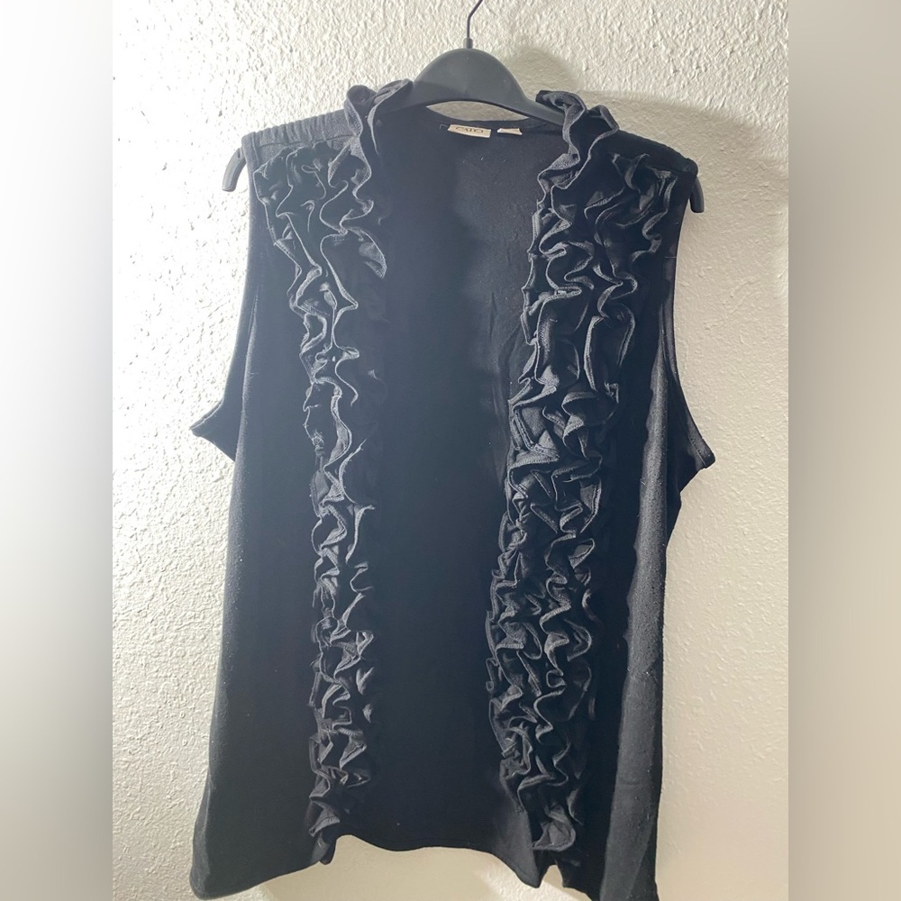 Black knit vest with‎ ruffle front.